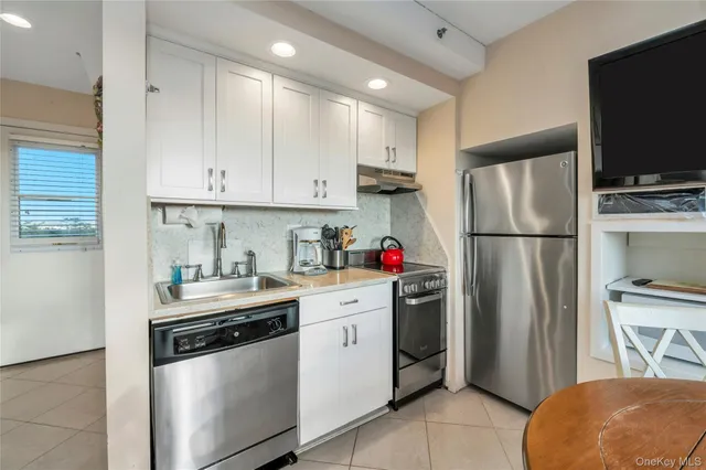 a kitchen with stainless steel appliances a refrigerator sink and cabinets