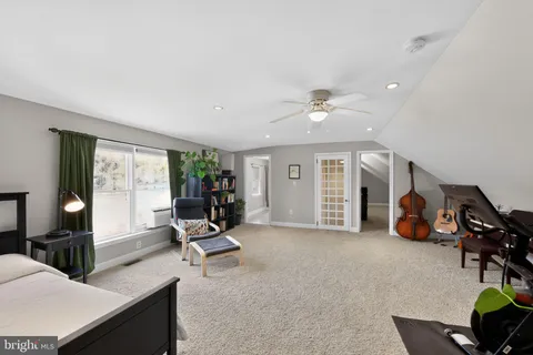 a living room with furniture gym equipment and large windows