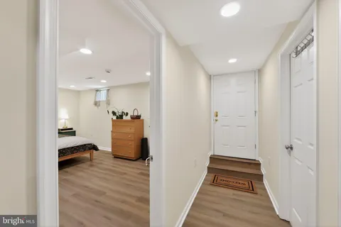 a view of a hallway with wooden floor and furniture