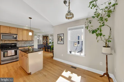 a kitchen with stainless steel appliances granite countertop a hardwood floor sink stove and granite counter top