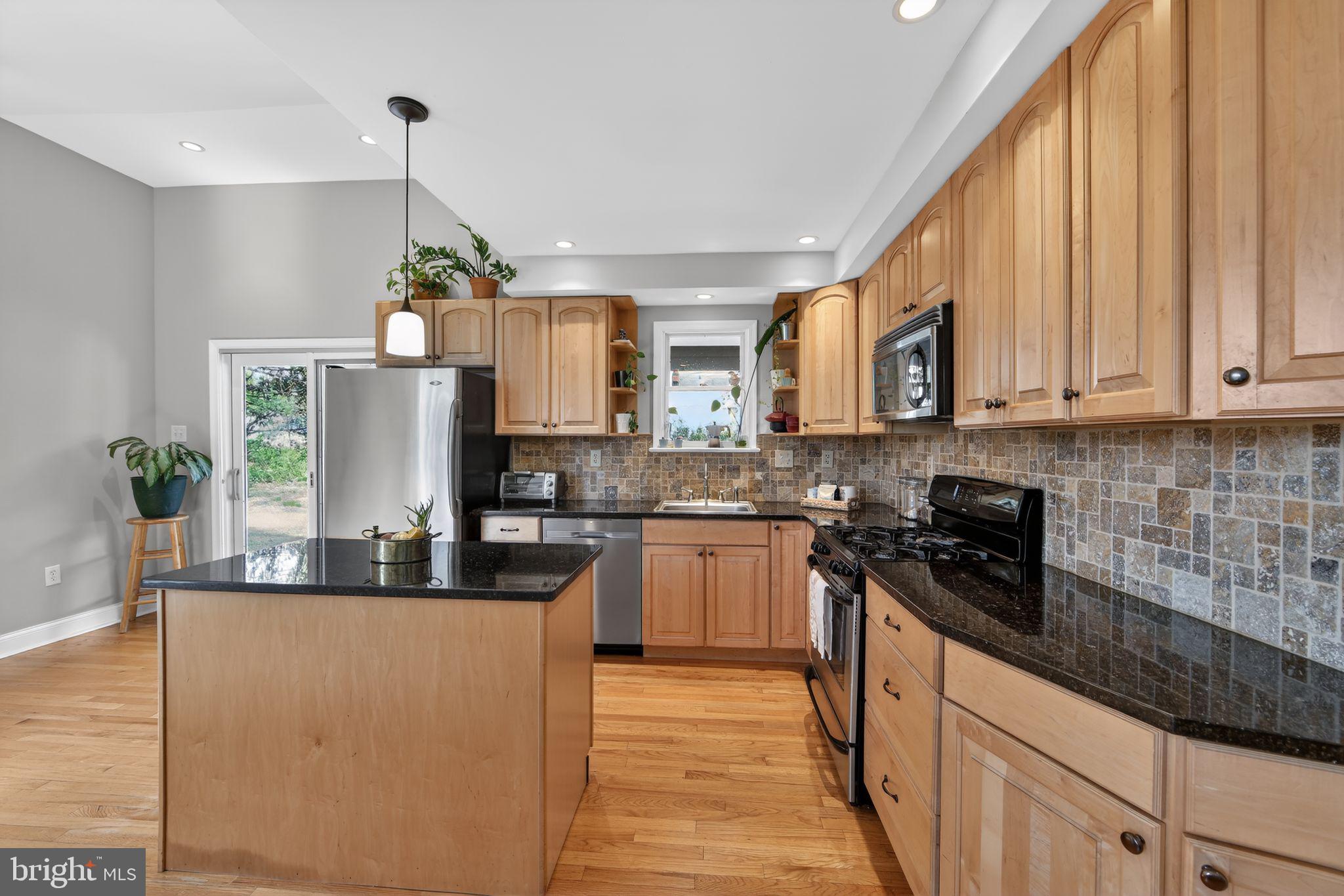 14 North Concord Road West Chester, PA 19380 - Photo 8 of 25 a kitchen with kitchen island granite countertop a sink a counter space appliances and cabinets