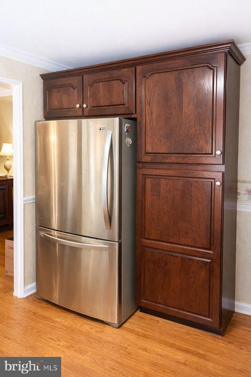 9839 Branchleigh Road Randallstown, MD 21133 - Photo 6 of 18 Sleek stainless steel fridge with wood cabinetry.