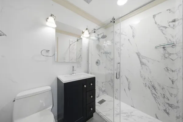 a bathroom with a sink a toilet and shower