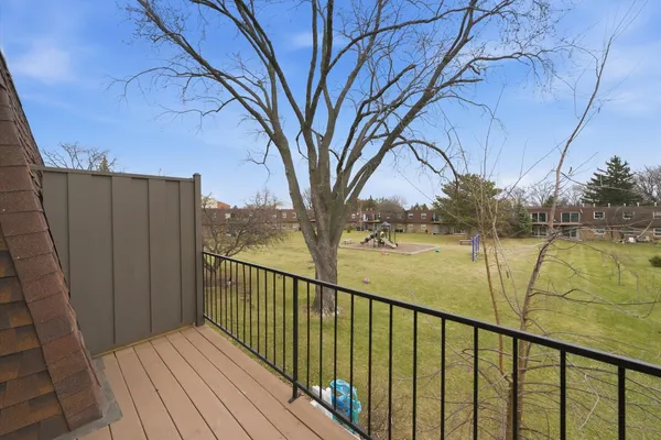 a view of balcony with wooden floor and fence