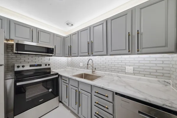a kitchen with granite countertop a sink stainless steel appliances and cabinets