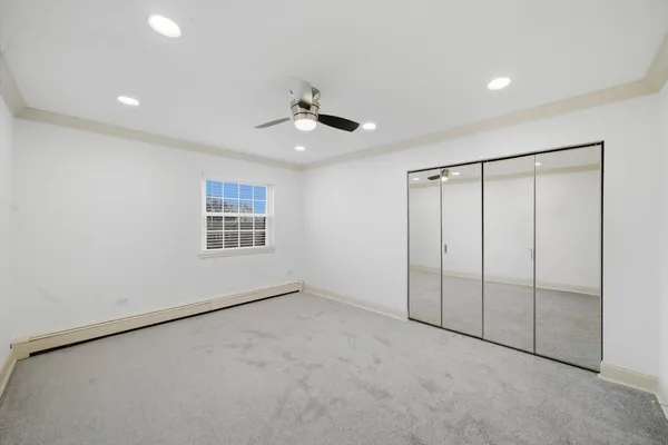 an empty room with windows and fan
