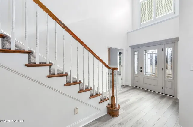 a view of staircase with lots of frames on wall and wooden floor
