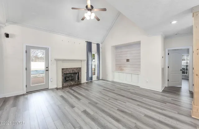 a view of empty room with wooden floor and fireplace