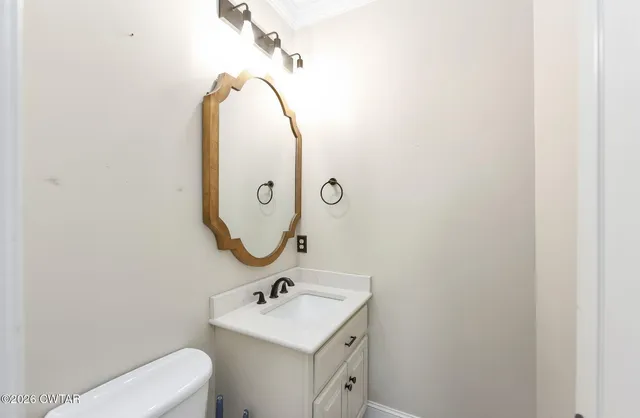 a bathroom with a toilet a sink and mirror