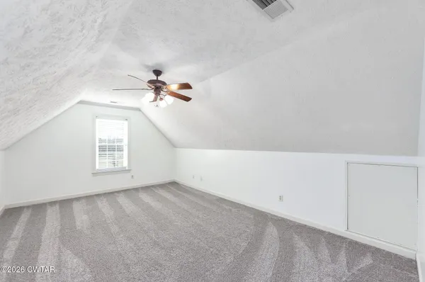 a view of an empty room with a ceiling fan and wooden floor