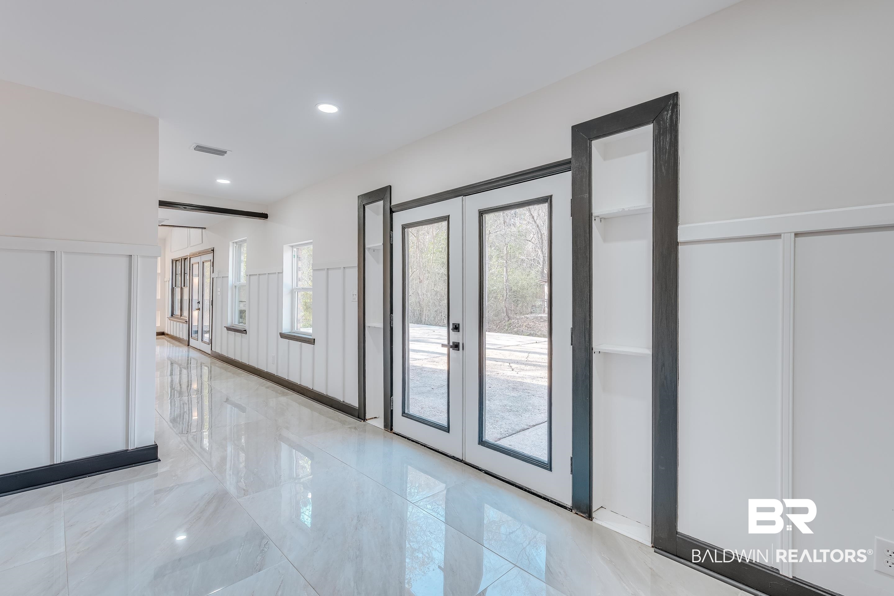 1190 Military Road Mount Vernon, AL 36560 - Photo 23 of 47 Doorway with french doors, a decorative wall, marble tiled floors, recessed lighting, and a wainscoted wall