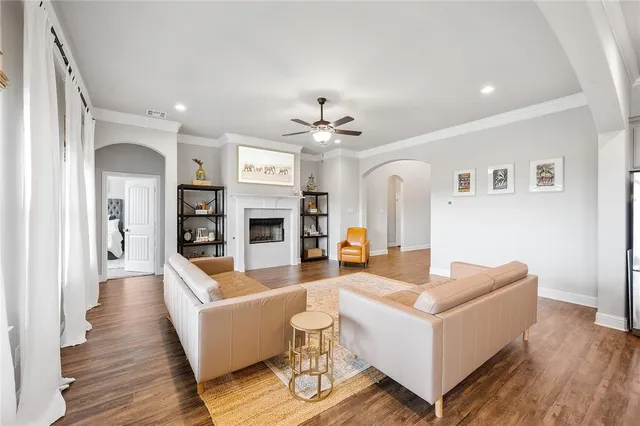 a kitchen with stainless steel appliances granite countertop a sink dishwasher a refrigerator with wooden cabinets and floor