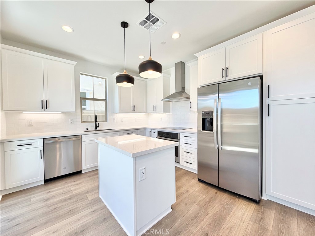 29561 Monarch Road Menifee, CA 92586 - Photo 11 of 35 a kitchen with a refrigerator sink and cabinets