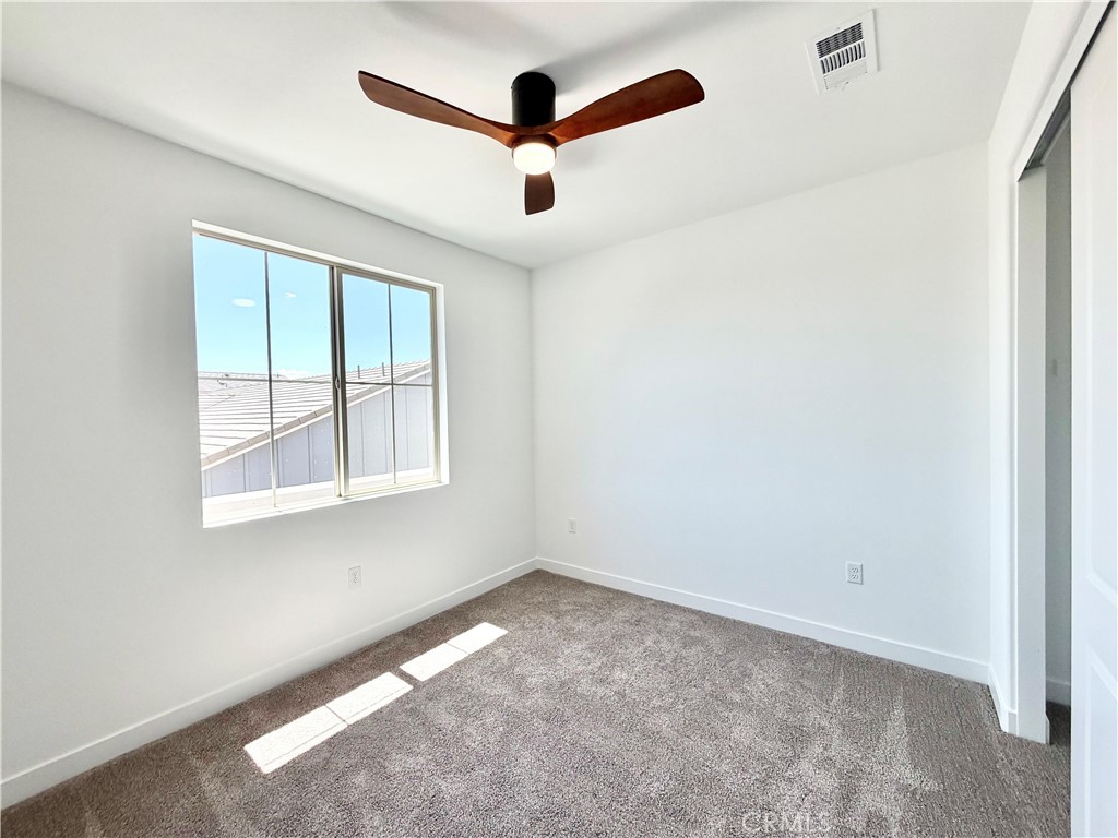 29561 Monarch Road Menifee, CA 92586 - Photo 26 of 35 an empty room with ceiling fan and window