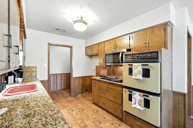 a kitchen with stainless steel appliances granite countertop a stove and cabinets