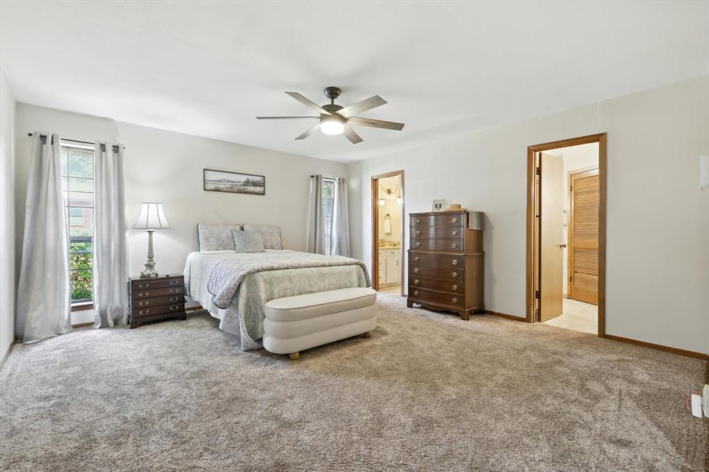 905 Clearview Drive Krum, TX 76249 - Photo 20 of 38 a spacious bedroom with a bed and a chandelier