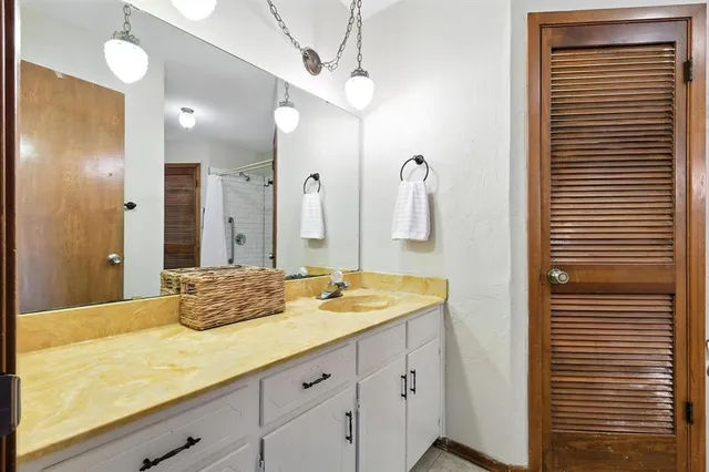 a bathroom with a granite countertop sink and a mirror