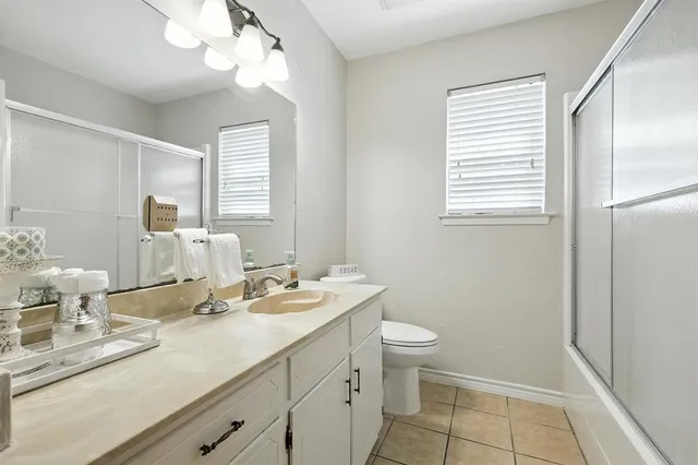 a bathroom with a double vanity sink a toilet and a mirror