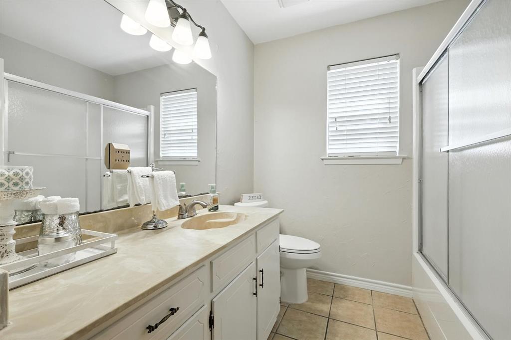 905 Clearview Drive Krum, TX 76249 - Photo 28 of 38 a bathroom with a double vanity sink a toilet and a mirror