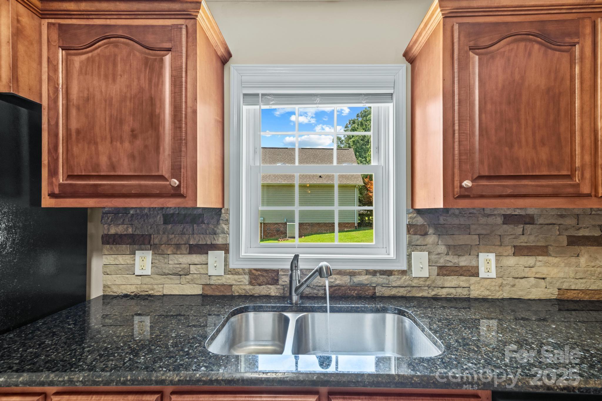 2133 Olde Farm Road Southeast Hudson, NC 28638 - Photo 13 of 42 a kitchen with granite countertop wooden cabinets a sink and a window