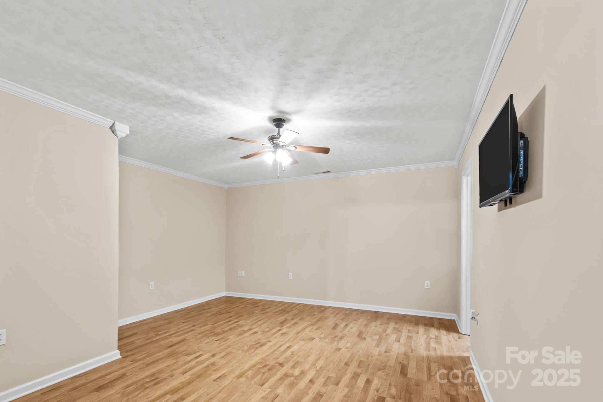 2133 Olde Farm Road Southeast Hudson, NC 28638 - Photo 26 of 42 an empty room with wooden floor fan and windows