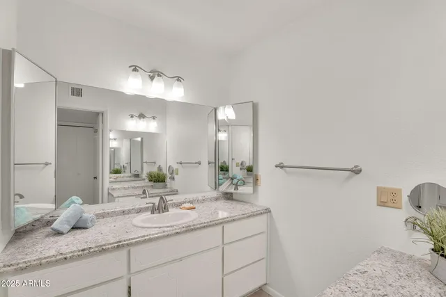 an empty room with chandelier fan and windows