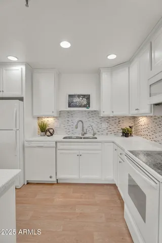 a kitchen with white cabinets appliances and a sink