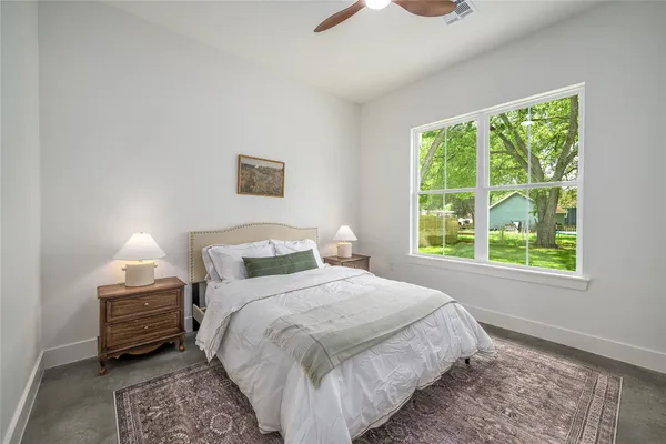 a bedroom with a bed a lamp and a large window