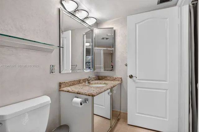 a bathroom with a granite countertop sink and a mirror