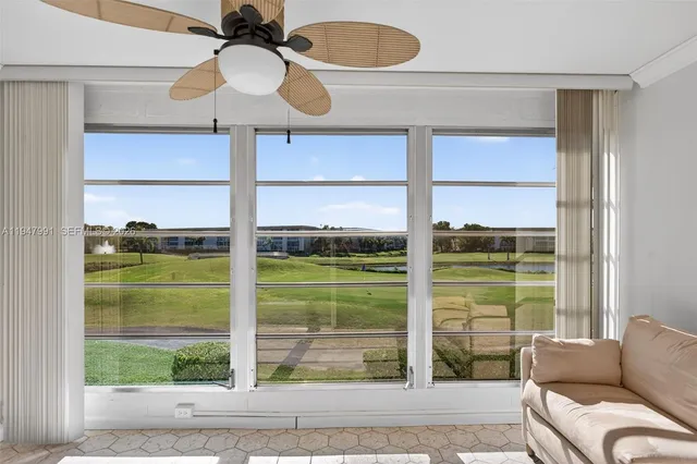 a living room with a large window and chandelier