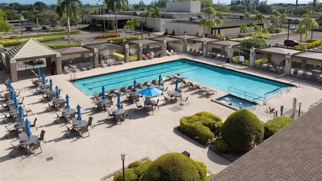 a view of a swimming pool with outdoor seating and a garden