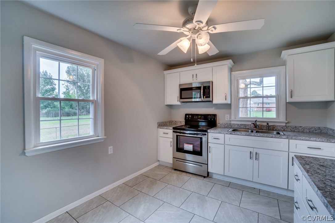 5525 Jahnke Road Richmond, VA 23225 - Photo 21 of 35 a kitchen with stainless steel appliances granite countertop a stove top oven a sink a window and cabinets