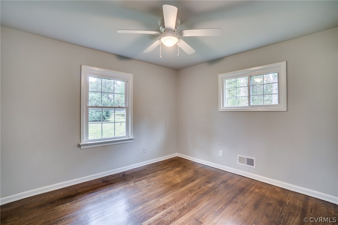 5525 Jahnke Road Richmond, VA 23225 - Photo 31 of 35 an empty room with wooden floor chandelier fan and windows