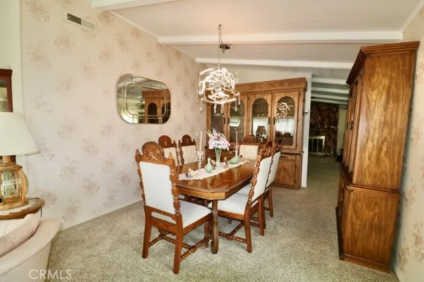 a view of a dining room with furniture a chandelier and wooden floor