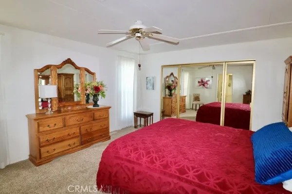 a bed room with a bed mirror and a ceiling fan