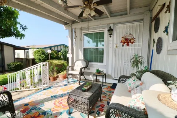 a view of a patio with couches table and chairs and potted plants