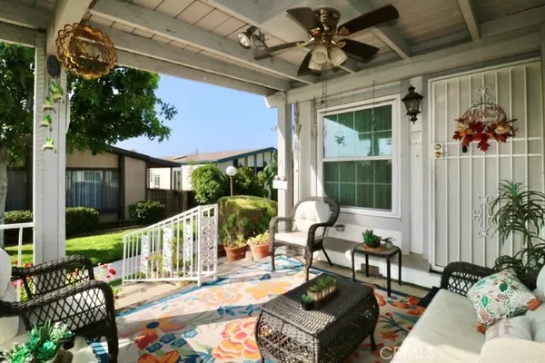 a view of a patio with couches table and chairs and potted plants