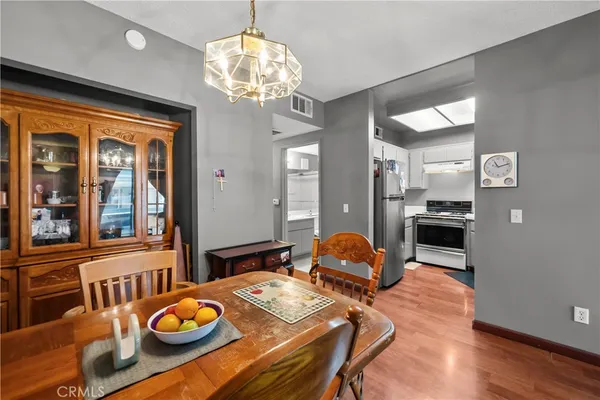 a view of a dining room with furniture a chandelier and wooden floor