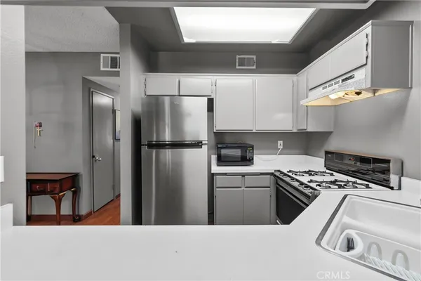 a kitchen with stainless steel appliances a refrigerator a stove and a sink