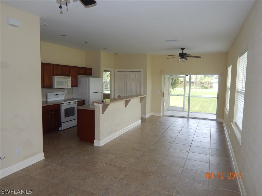 12780 River Road Fort Myers, FL 33905 - Photo 4 of 24 a large kitchen with stainless steel appliances a sink a stove a microwave a refrigerator and cabinets