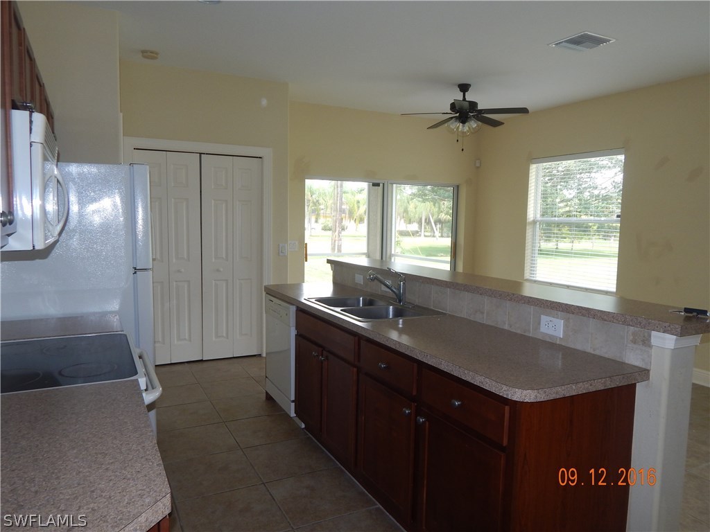 12780 River Road Fort Myers, FL 33905 - Photo 5 of 24 a kitchen with a refrigerator and a sink