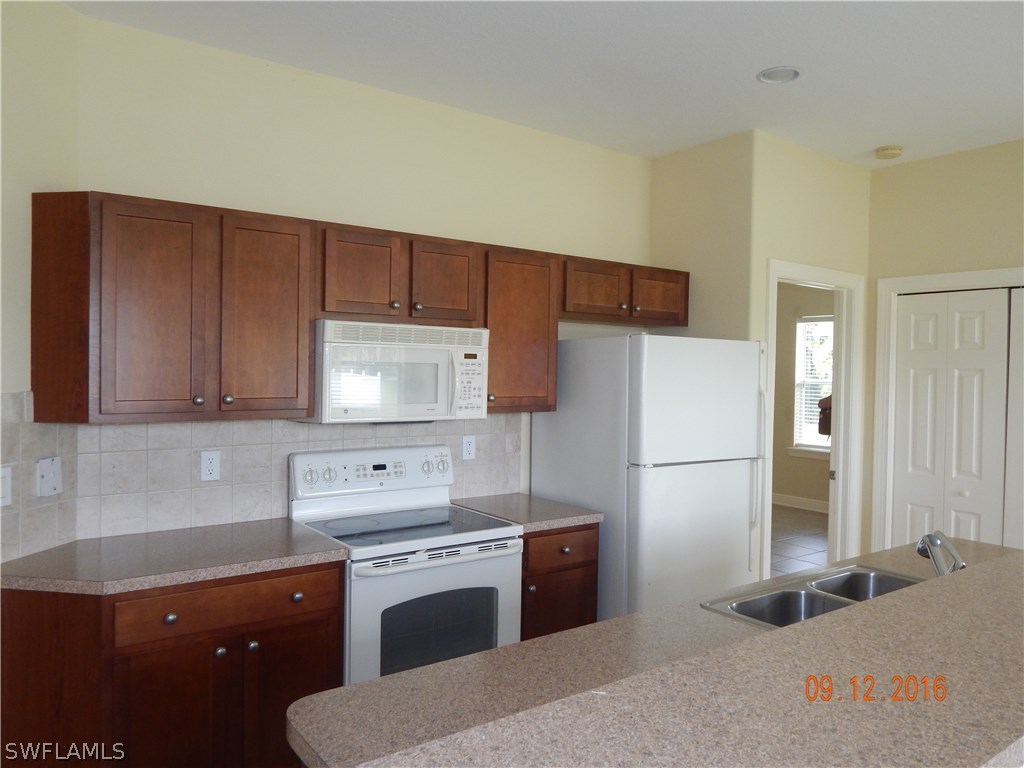 12780 River Road Fort Myers, FL 33905 - Photo 6 of 24 a kitchen with a refrigerator sink stove and cabinets