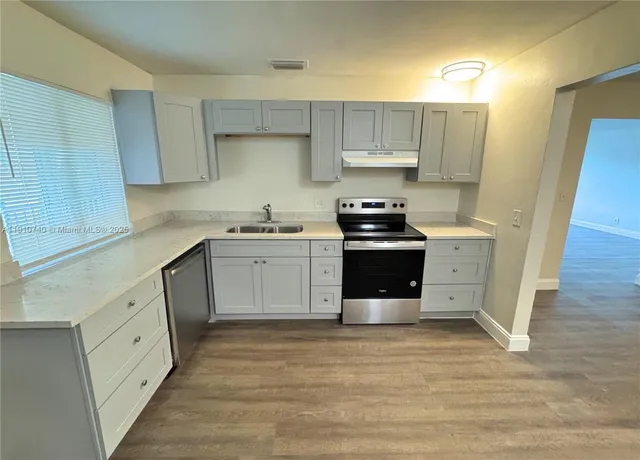 a kitchen with stainless steel appliances a stove top oven and cabinets
