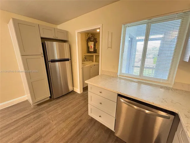 a kitchen with granite countertop a refrigerator and a sink