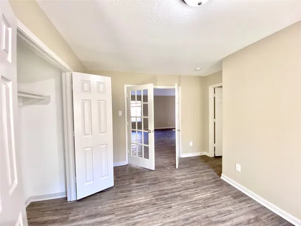 a view of empty room with wooden floor