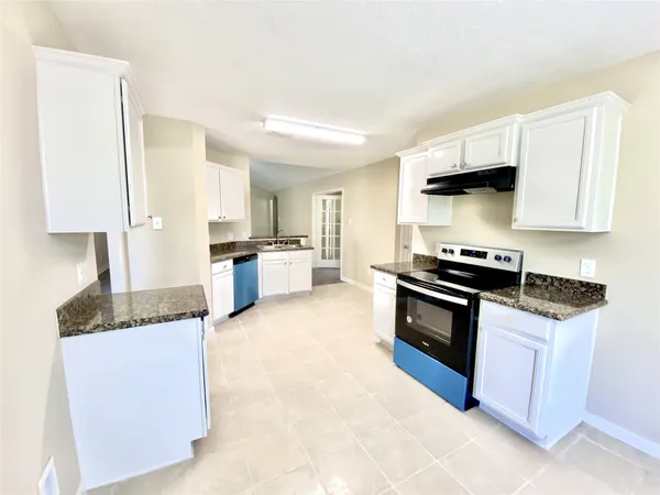 a kitchen with granite countertop a stove and a sink