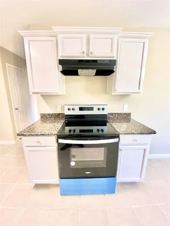 a stove top oven sitting inside of a kitchen