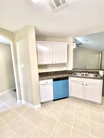 a large white kitchen with a sink a stove a refrigerator and a window