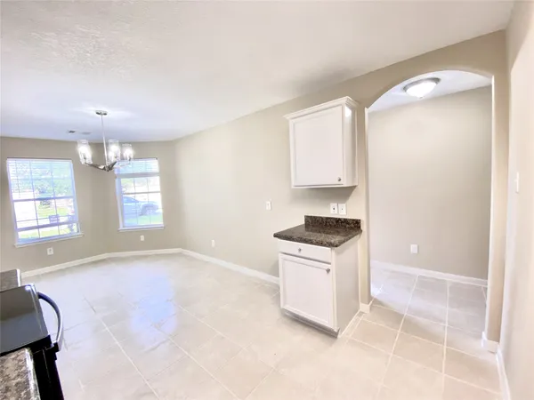 a kitchen with granite countertop a stove a sink and a refrigerator