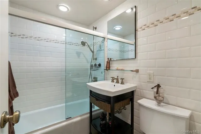a bathroom with a sink shower and a mirror